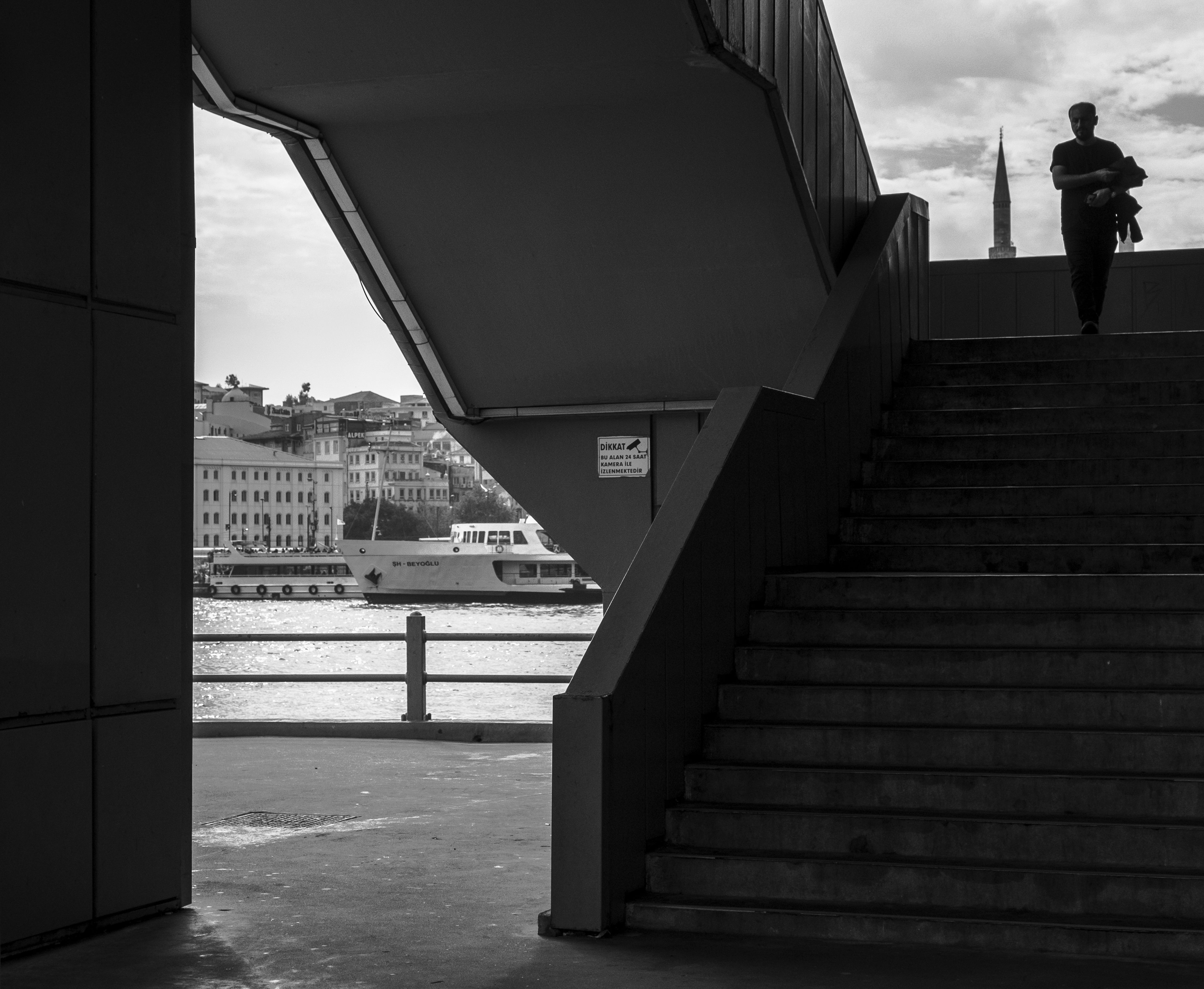 Black and White Photo of a Man Walking Down the Stairs · Free Stock Photo