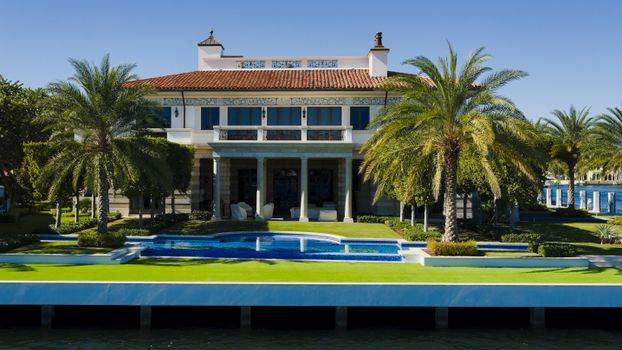 Elegant tropical villa in Fort Lauderdale featuring a lush garden and pool.