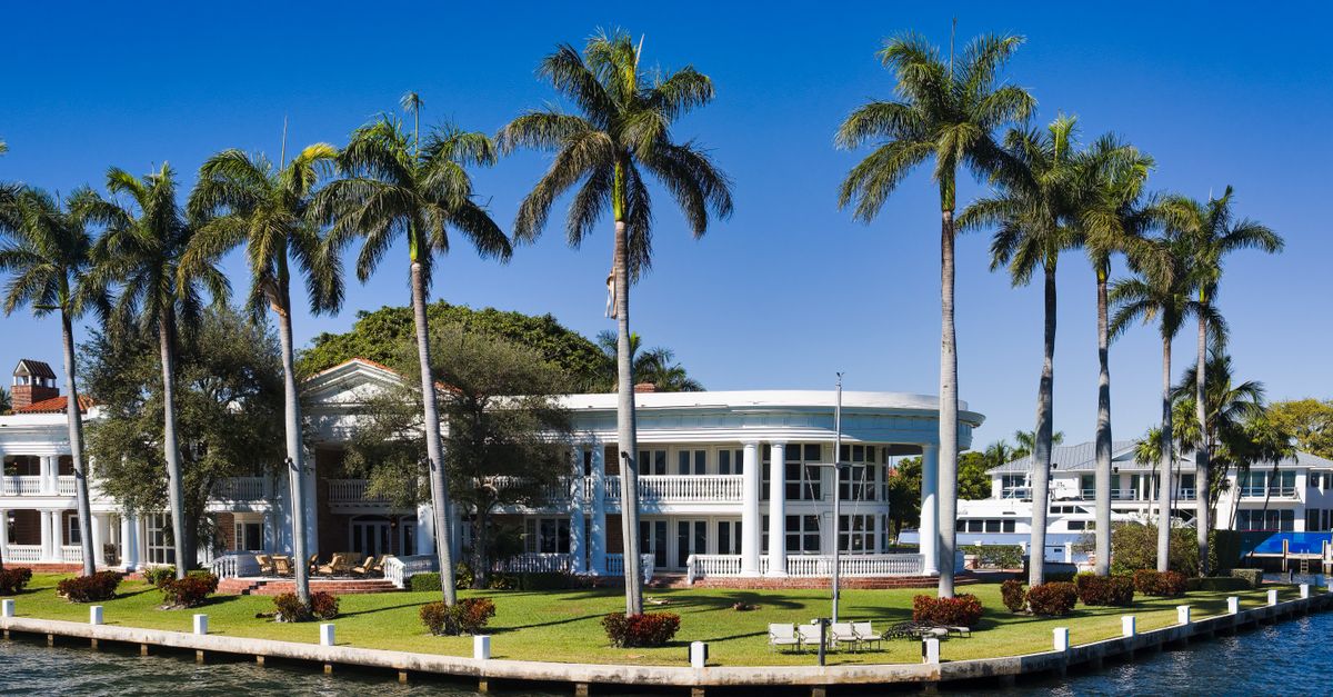 Elegant waterfront mansion with palm trees in Fort Lauderdale, Florida.