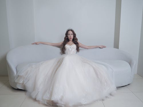 Woman in White Dress sitting on the Couch