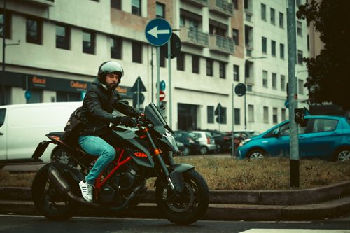 Free Male motorcyclist riding through Milan city streets, showcasing urban lifestyle. Stock Photo