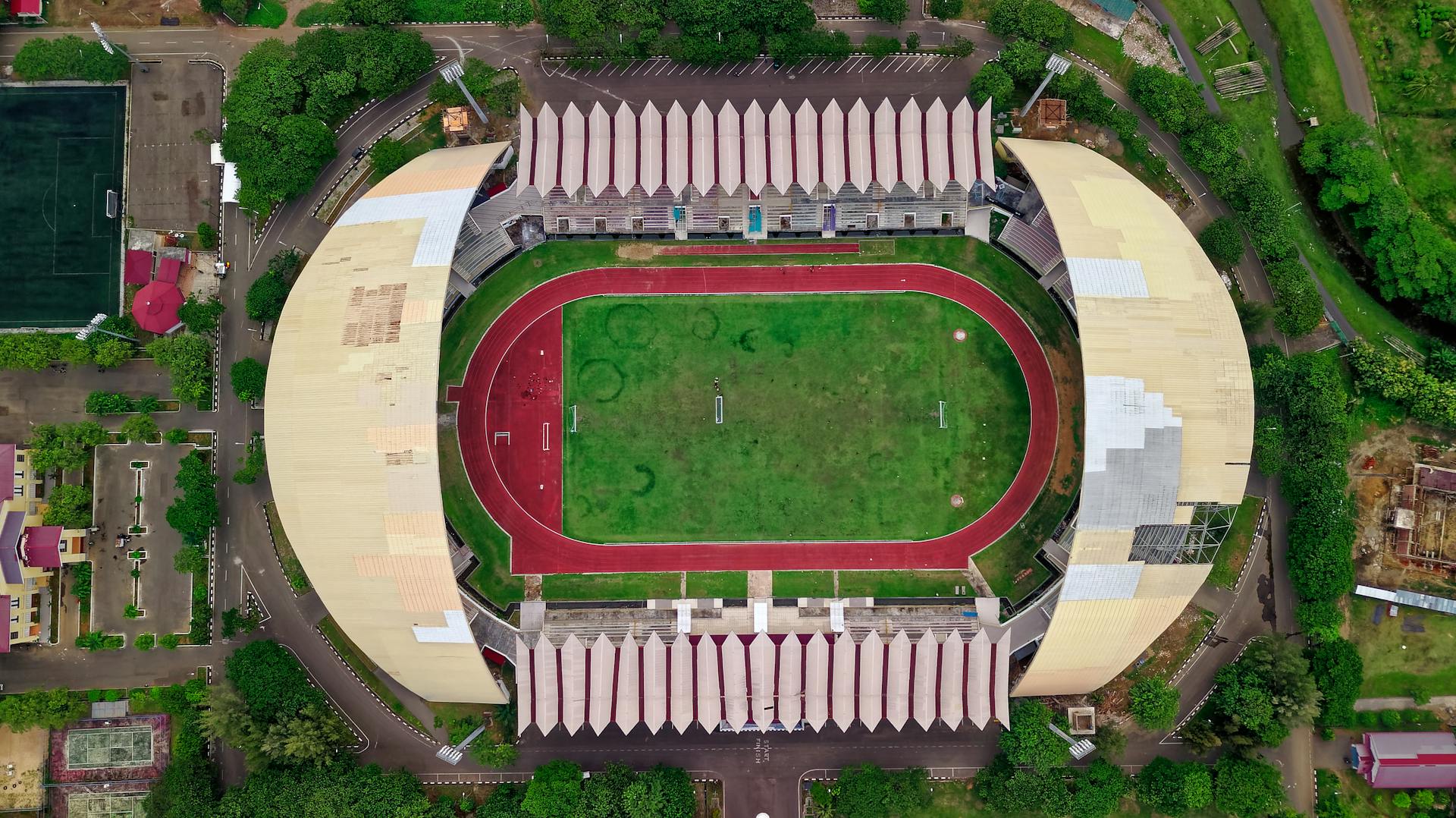 Aerial view of Baiturrahman Stadium in Aceh, Indonesia showcasing its architecture and sports field.