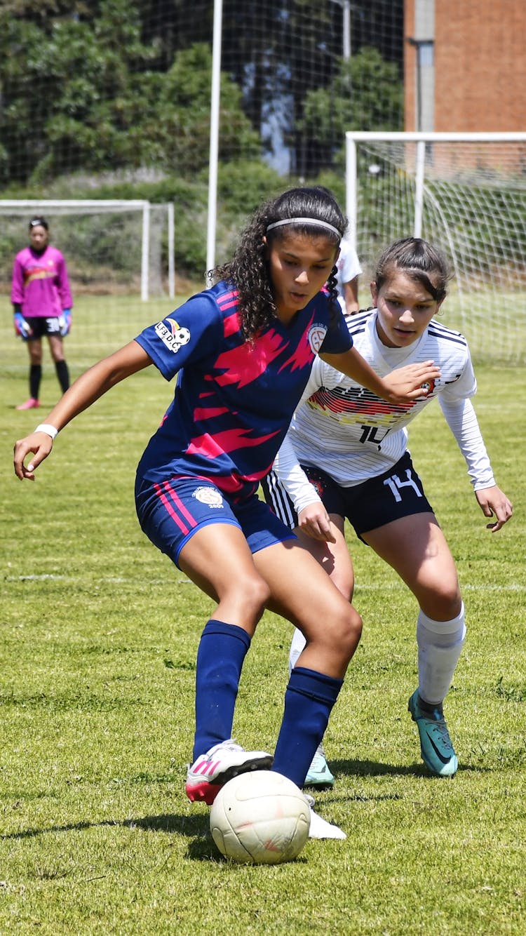 Girls Playing Football On Pitch