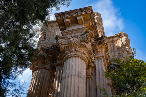 Free Low angle shot of ancient architectural columns with intricate carvings under a clear blue sky. Stock Photo