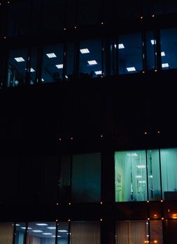 Night view of a multi-story office building with illuminated windows showcasing modern interior lighting.