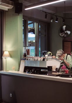 A barista makes espresso in a trendy coffee shop interior, focusing on quality and precision.