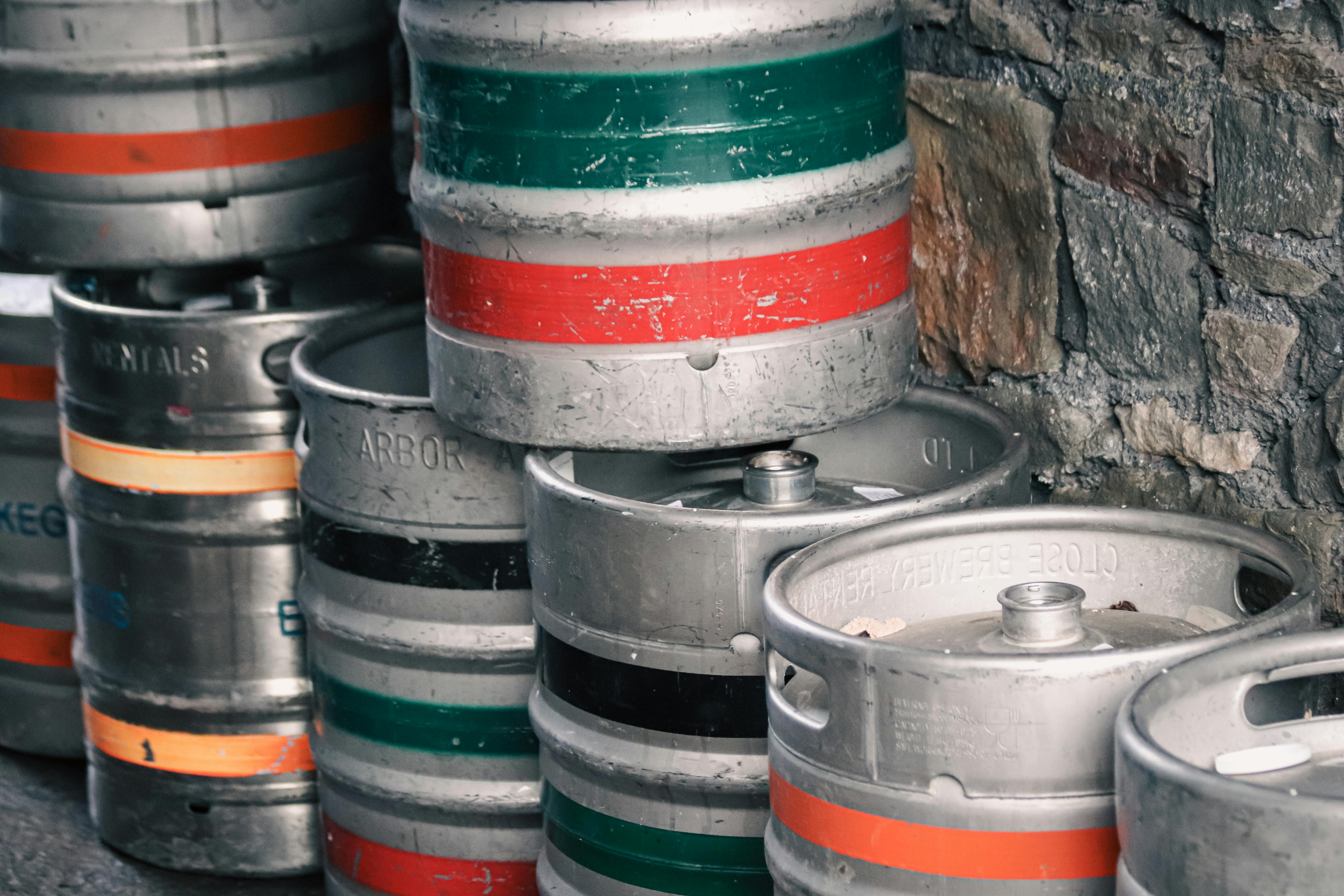 Beer Kegs Stack Near Wall · Free Stock Photo