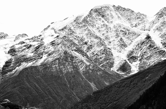 Stunning black and white photo of a rugged snowy mountain landscape showcasing nature's grandeur.