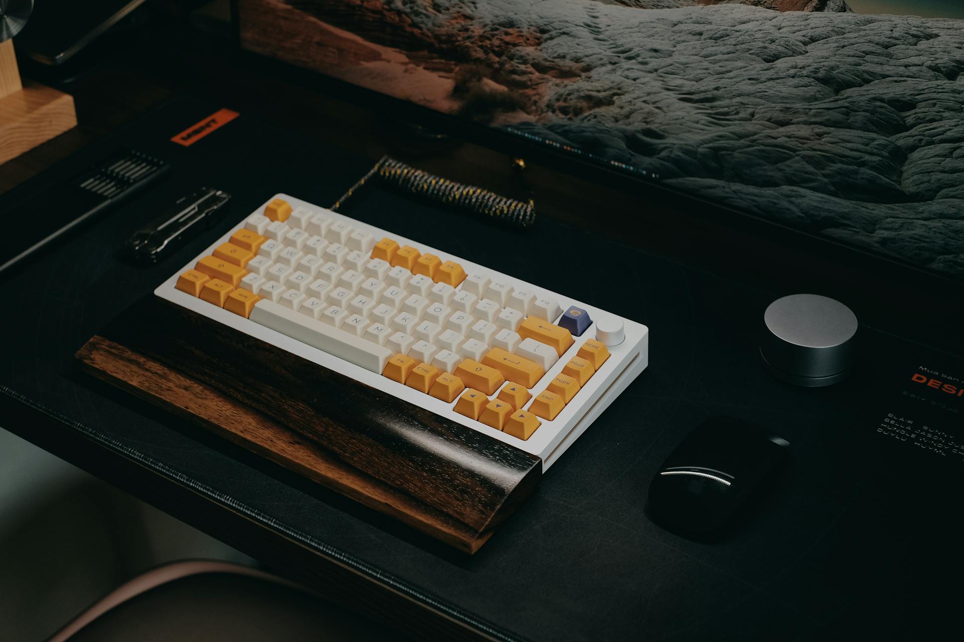 A sleek mechanical keyboard setup on a dark wooden desk in a modern home office environment.