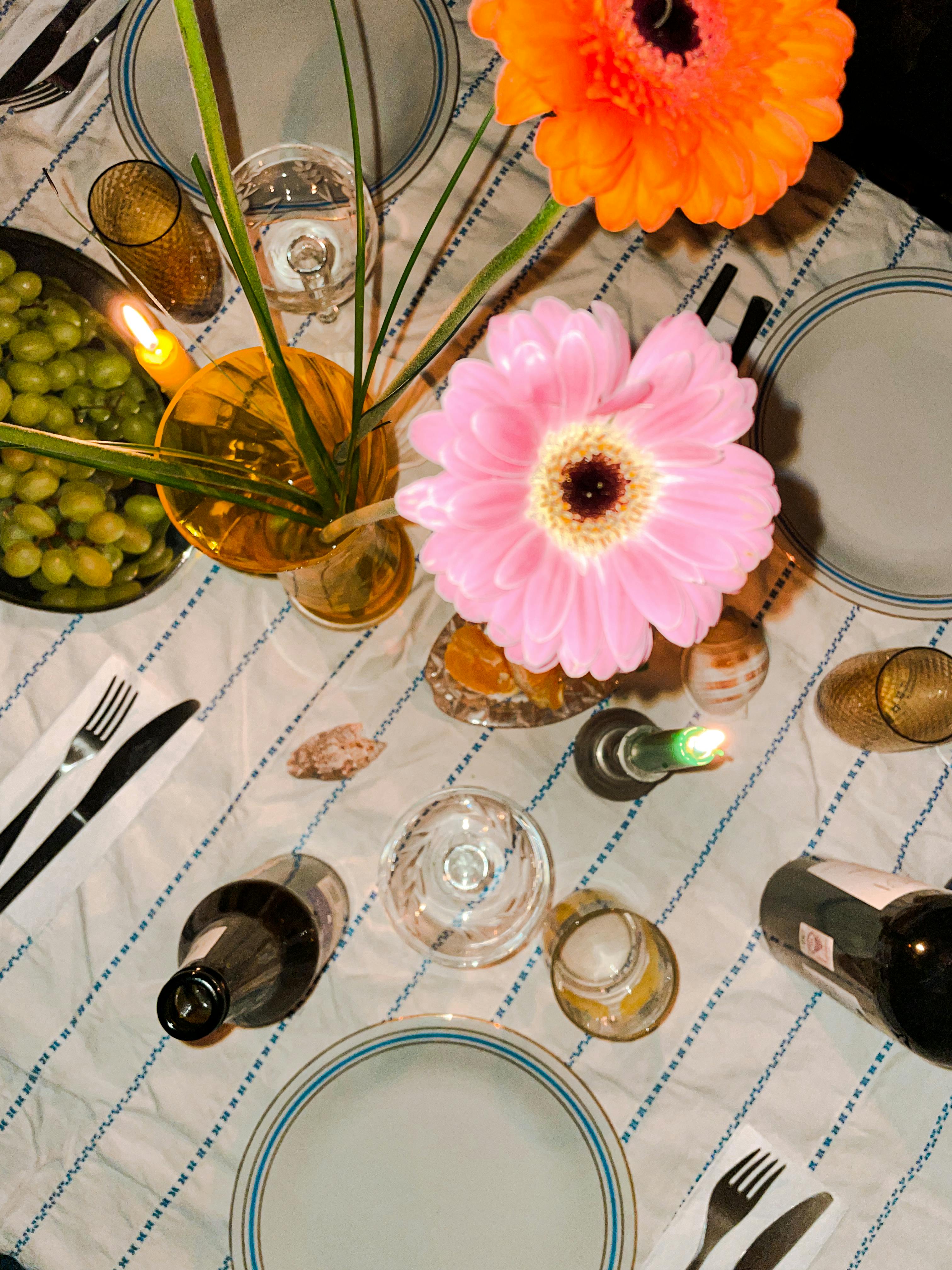 Top view of a beautifully arranged dinner table with flowers, grapes, and wine in Wrocław, Poland.