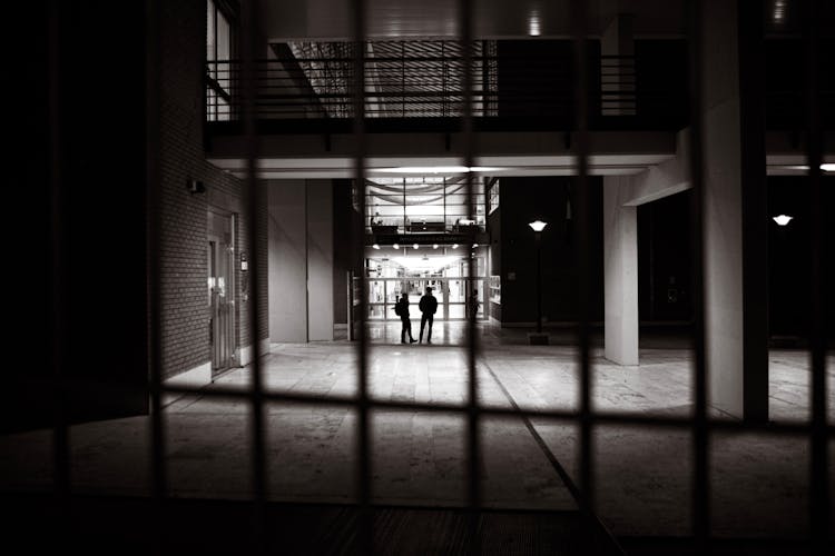 Silhouettes Of People Standing In Hallway
