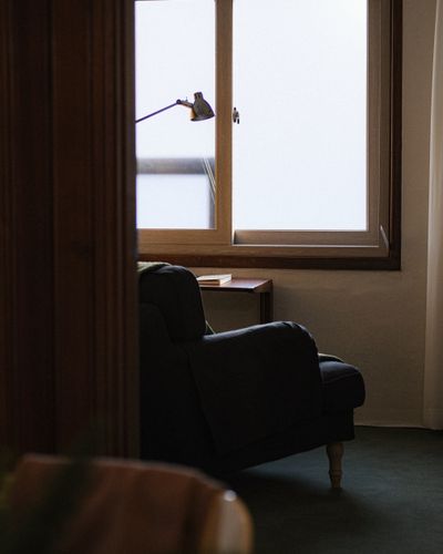 A comfortable armchair by a window in a peaceful, warm-lit interior