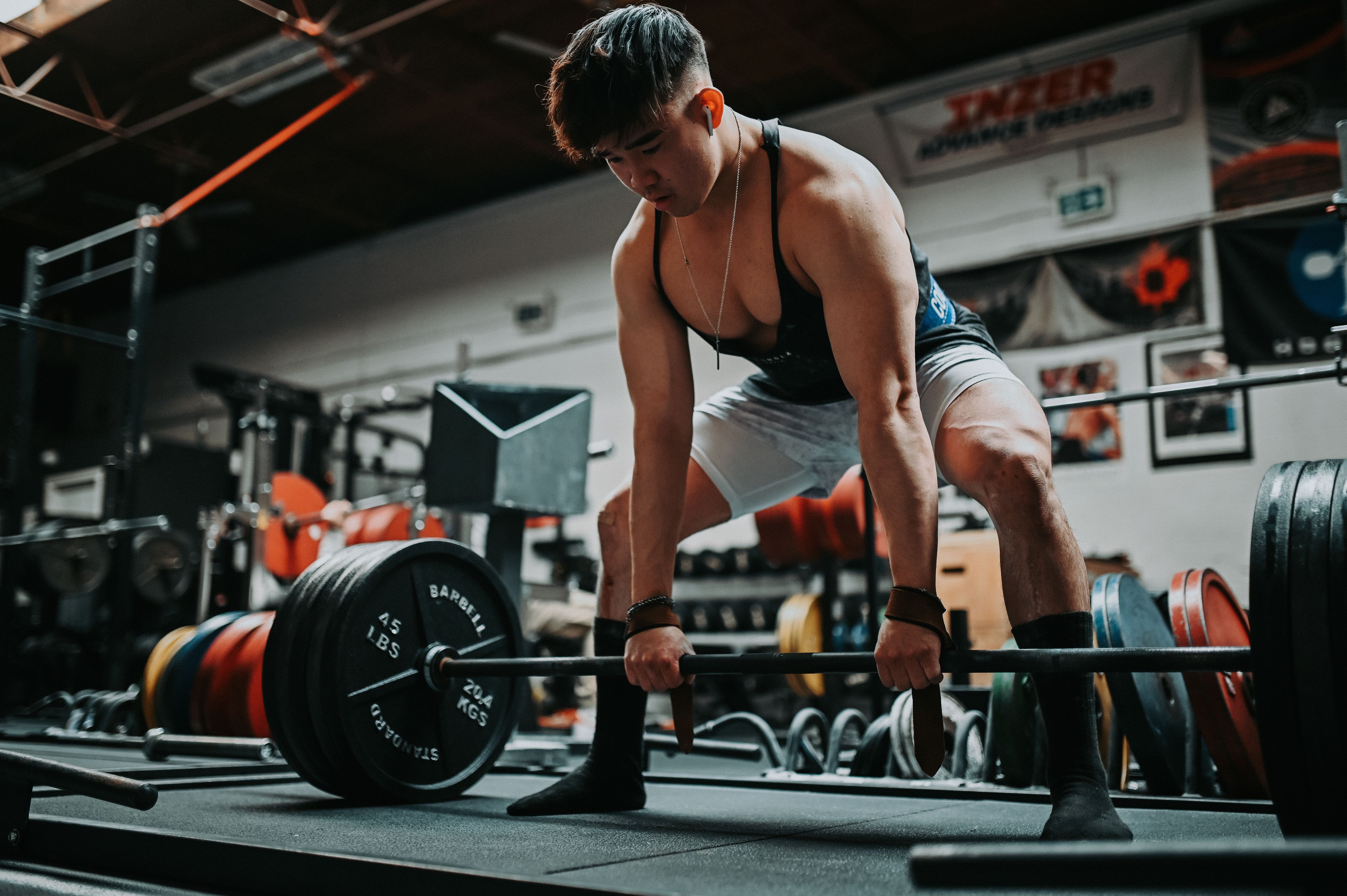 A man performs a deadlift in a gym, showcasing strength and athletic focus.