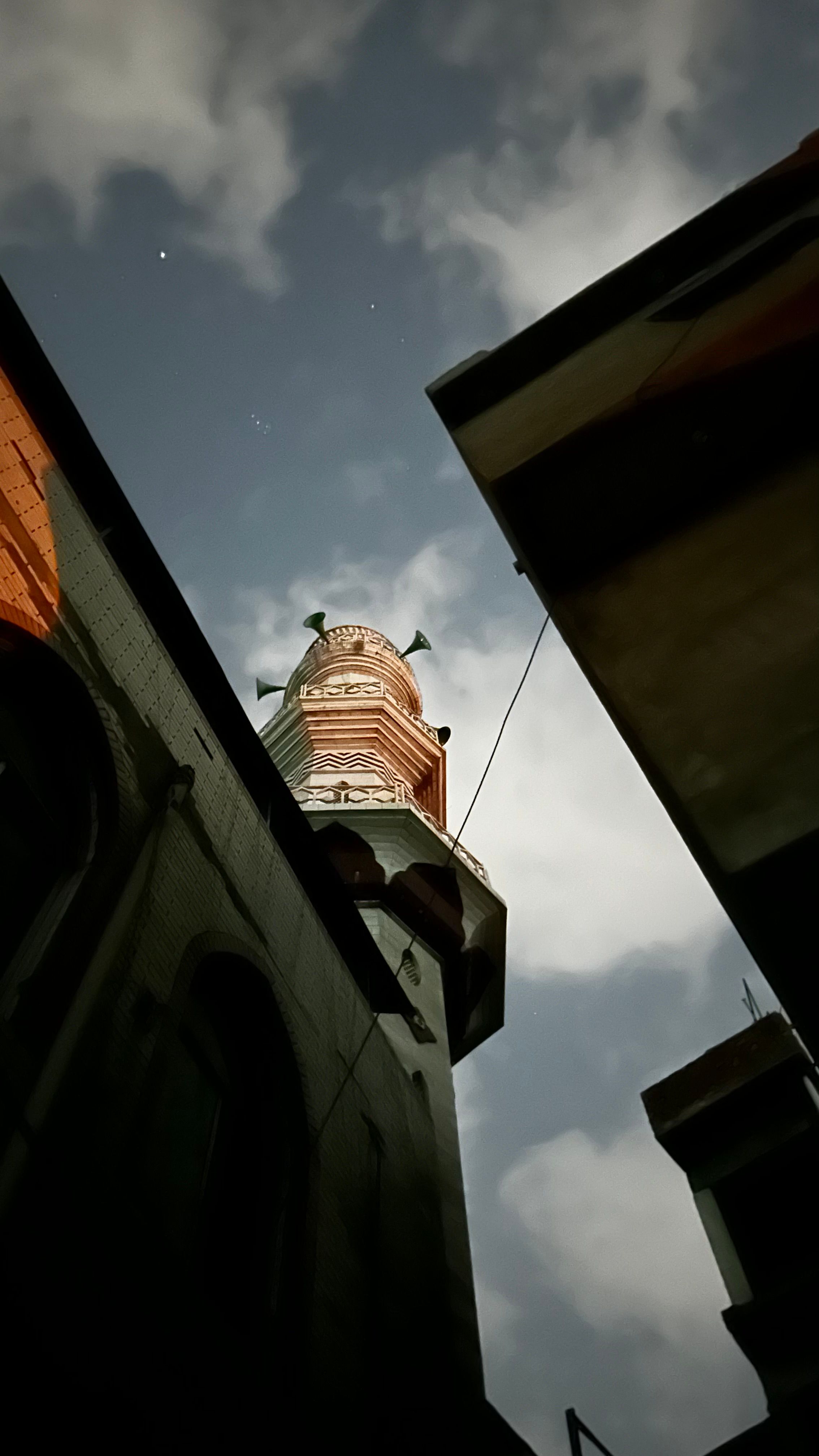 Low angle shot of a towering structure silhouetted against a cloudy evening sky.