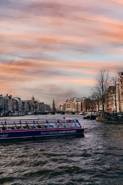 Passenger Ship on River in Town at Sunset