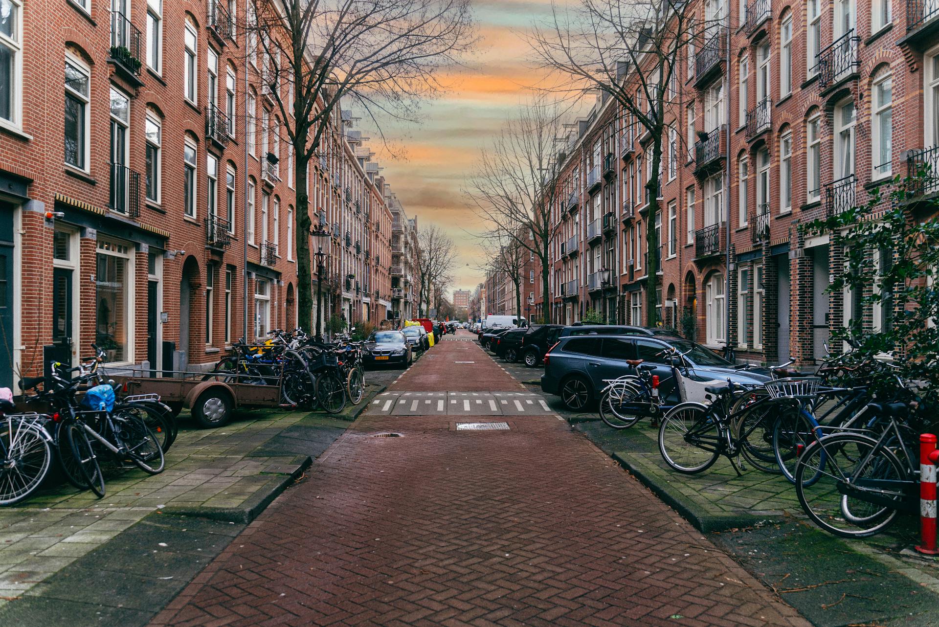 Explore this picturesque street in Amsterdam featuring iconic brick architecture and lined with bicycles.