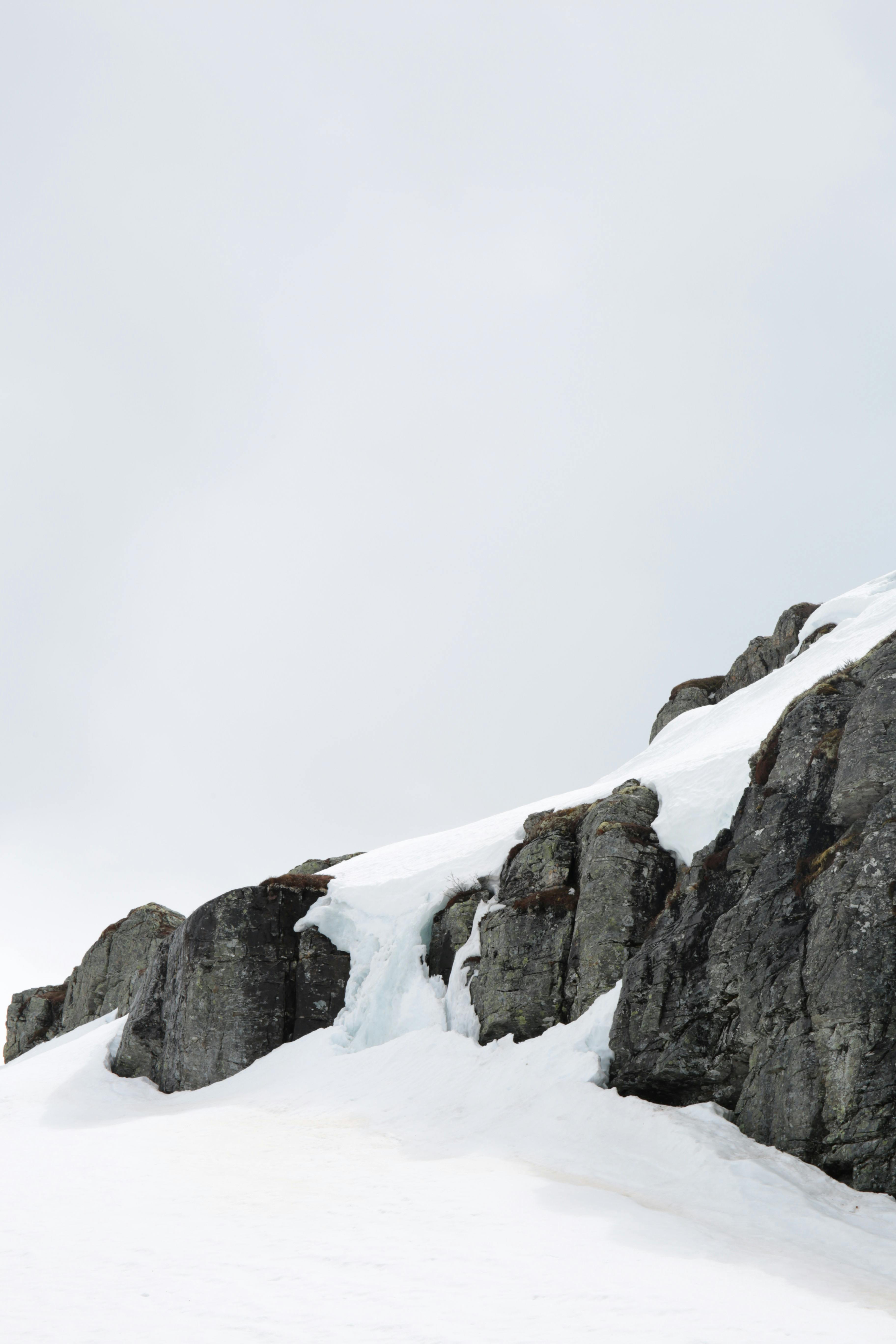 Prescription Goggle Inserts - Capture of a cold, eroded rocky terrain lightly dusted with snow under an overcast winter sky.