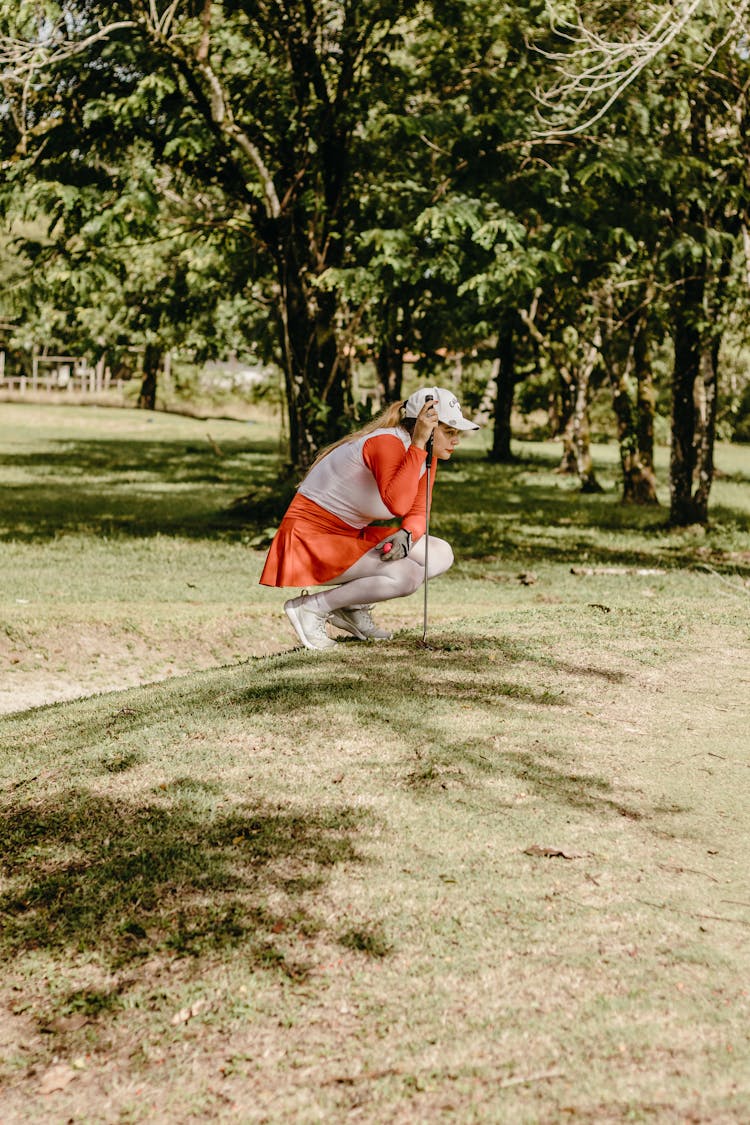 Woman Squatting And Playing Golf