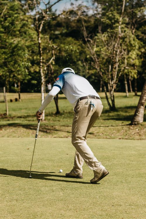 Free Golfer focusing on the next shot at a lush golf course on a bright day. Stock Photo