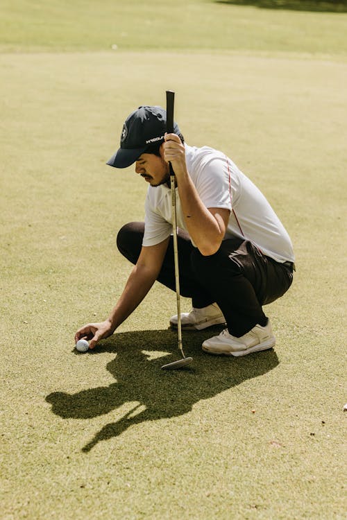 A Man Holding a Golf Ball and a Golf Club 
