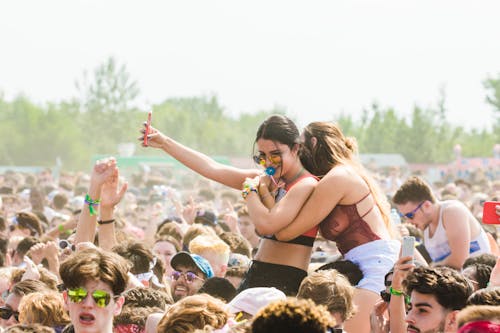 Free Two Women Embracing Surrounded by Crowd Stock Photo