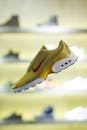 在模糊的商店背景中，一双时尚的黄色运动鞋营造出时尚的氛围