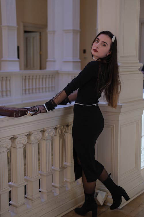 A Woman in Black Dress Standing Near the Concrete Railing