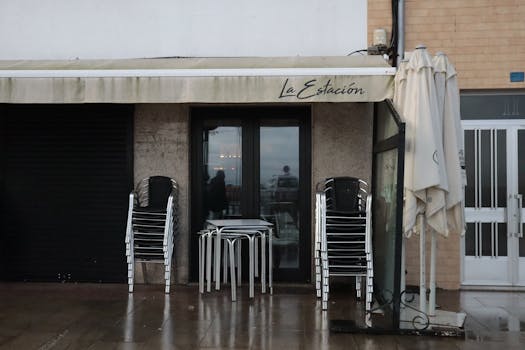 Stacked chairs outside La Estación café in Ribeira, Spain on a rainy day.
