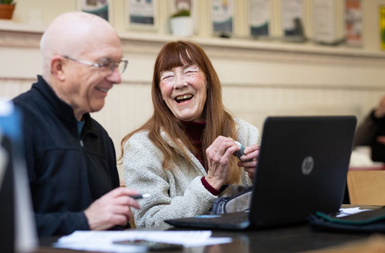 Laughing Couple At Desk With Laptop