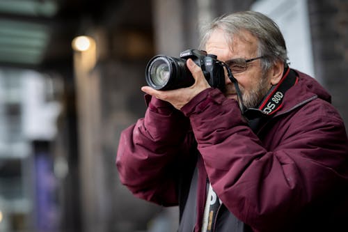 Gratis stockfoto met baard, bordeauxrode jas, camera