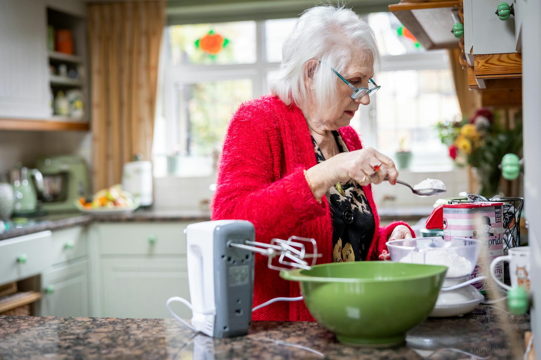 An older woman is cooking in the kitchen