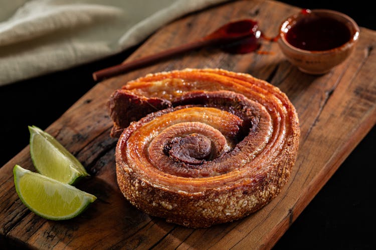 Photograph Of A Fried Pork Belly On A Wooden Chopping Board