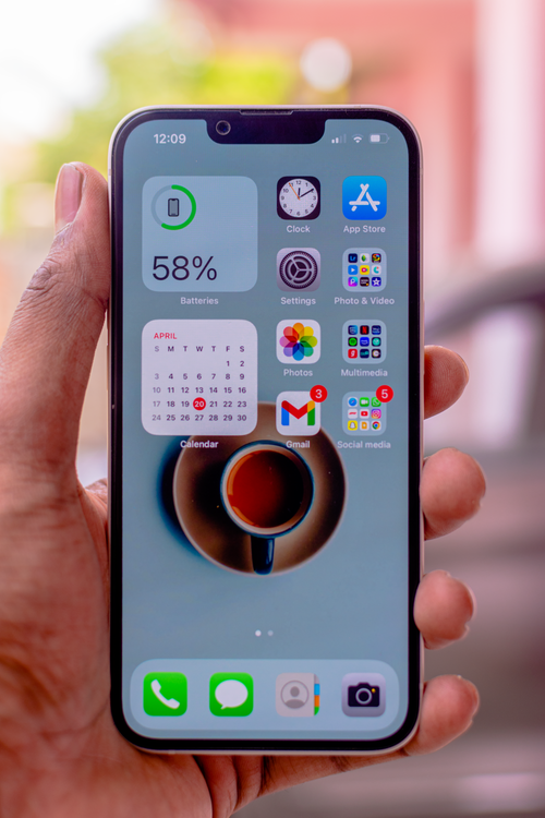 앱 아이콘이 보이는 iPhone을 손에 들고 있는 모습