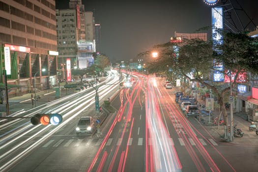 Vibrant city street at night with car light trails showcasing modern urban life.