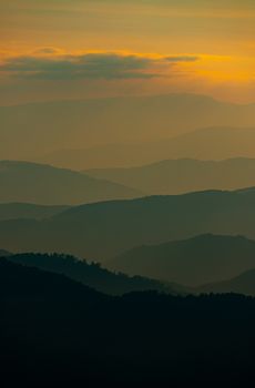 Captivating layers of misty mountain ranges at dusk in Kakanj, Bosnia.