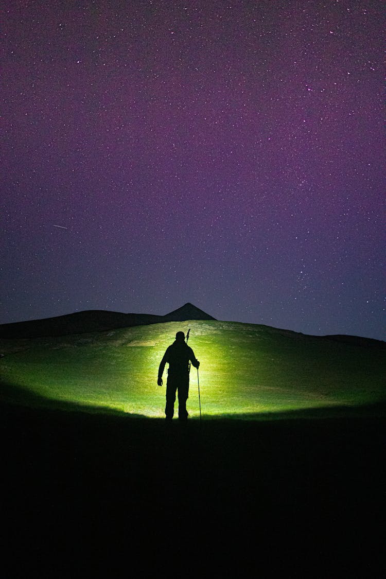 A Silhouette Of A Man Under A Starry Night Sky