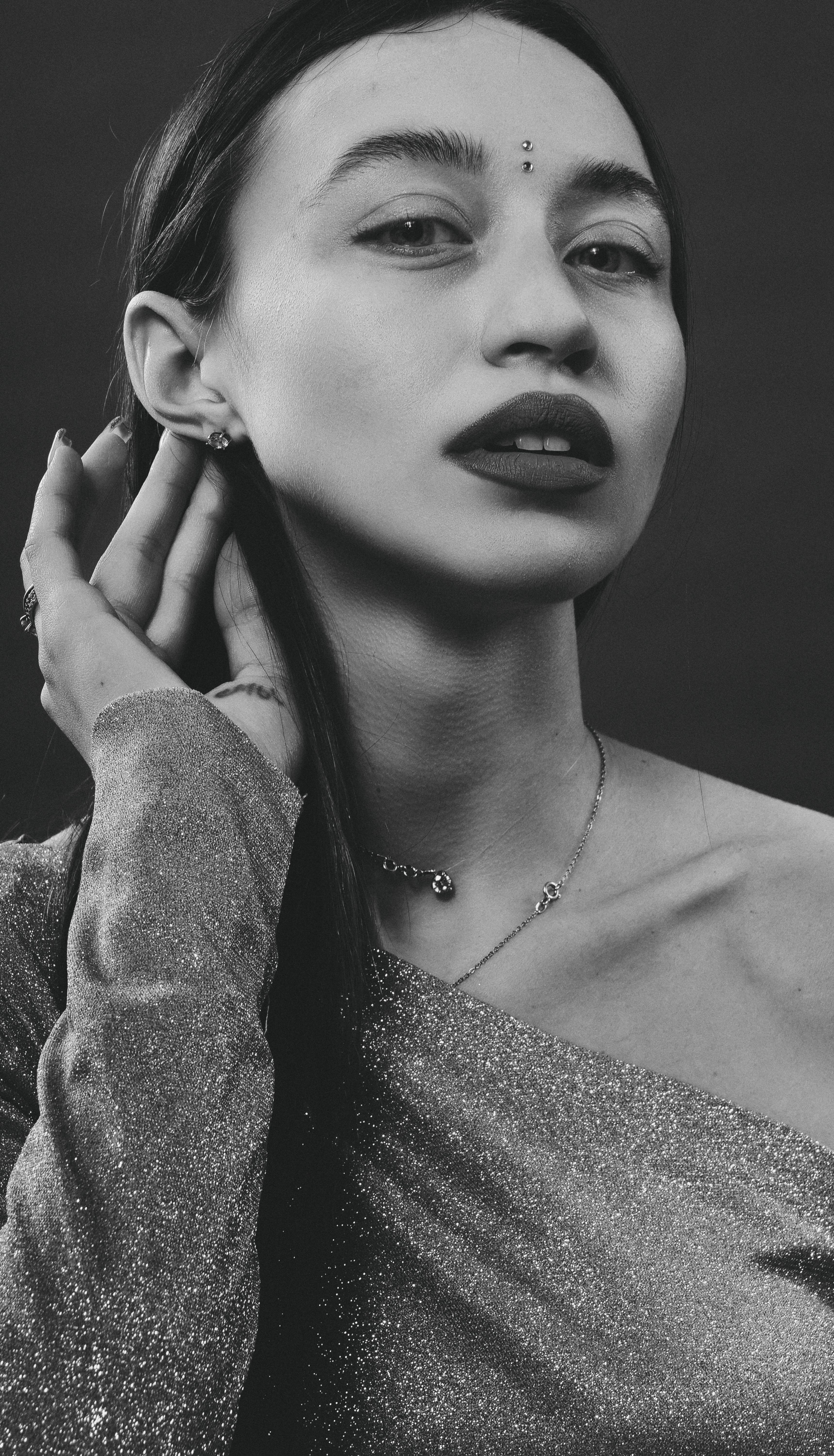 Artistic black and white portrait of a stylish young woman in a studio setting.