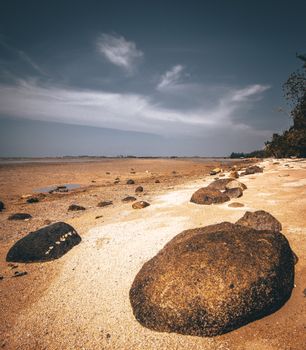 Rocky beach at low tide in Teluk Sebong, Riau Islands, Indonesia. Serene and scenic.