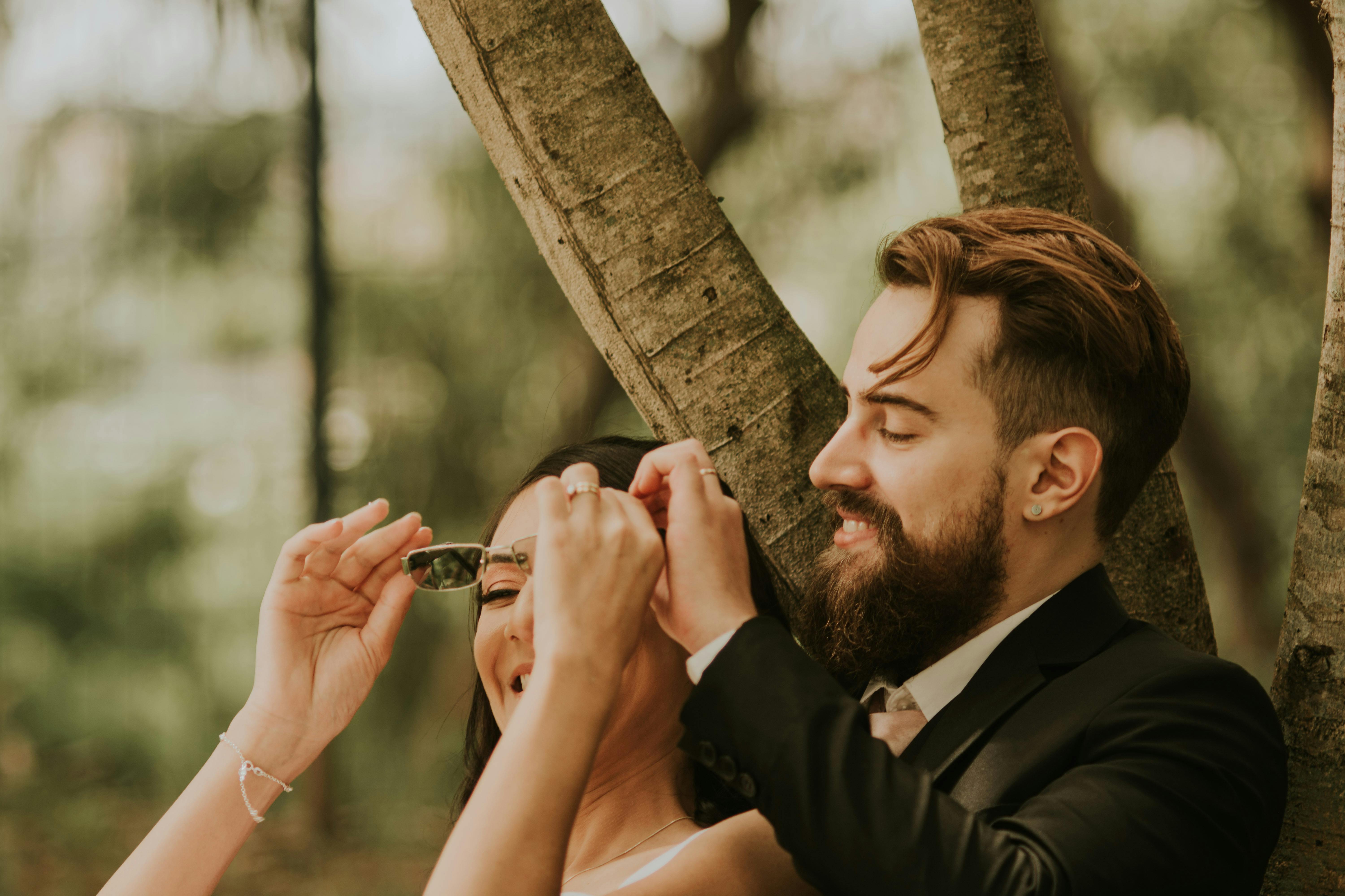 A candid shot of a happy couple sharing a private, romantic moment where one partner looks at the other with an expression of secret admiration and affection.