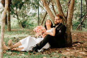 Photo of a Happy Young Couple Sitting Under a Tree