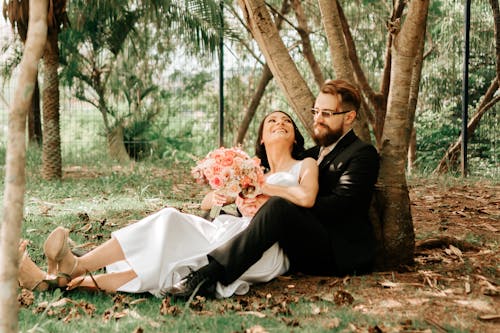 Free Photo of a Happy Young Couple Sitting Under a Tree Stock Photo