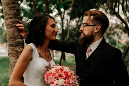 A romantic wedding portrait of a bride and groom gazing at each other outdoors.