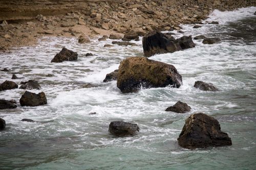 Free An inspiring view of waves crashing against the rocky seashore, depicting the power of nature. Stock Photo