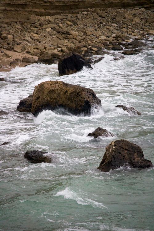 Free Capture of a rocky seacoast with waves crashing against the rocks, emphasizing nature's raw power. Stock Photo