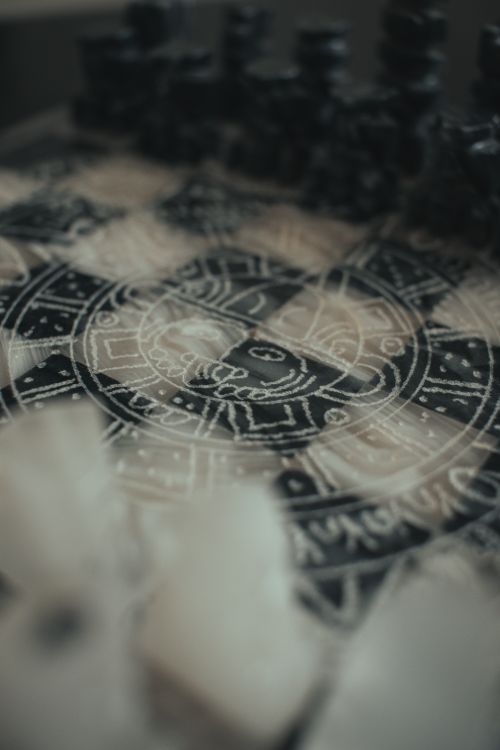 Free Close-up of a chessboard featuring detailed geometric designs and chess pieces. Stock Photo