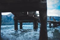 一座木制码头横跨在湛蓝的水面上，远方的山脉清晰可见