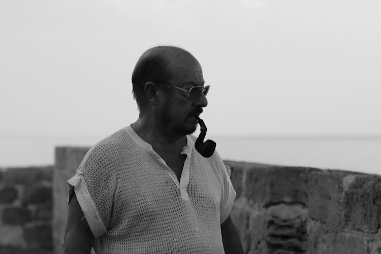 Black And White Photo Of A Pensive Man Smoking A Pipe