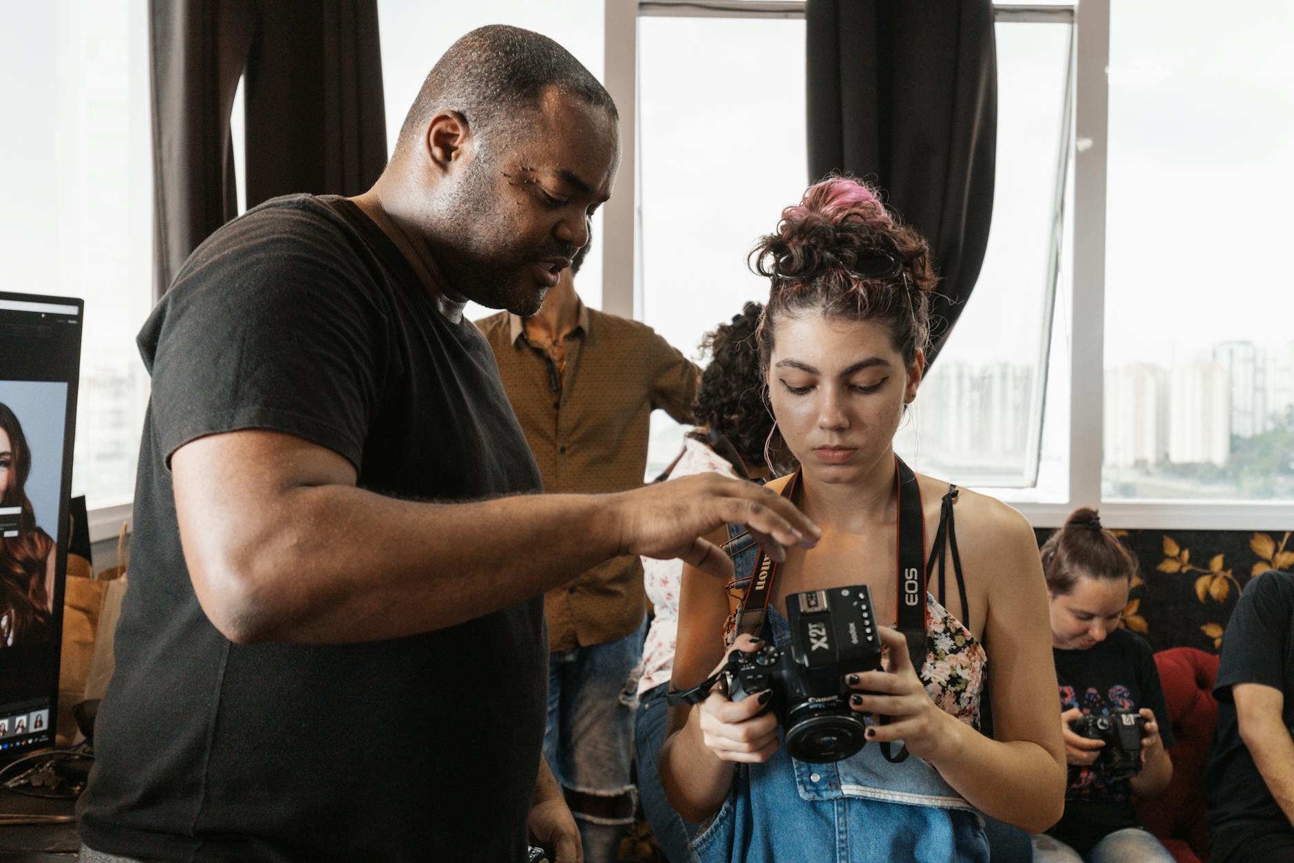Photographer instructing a young woman on camera techniques during a workshop.