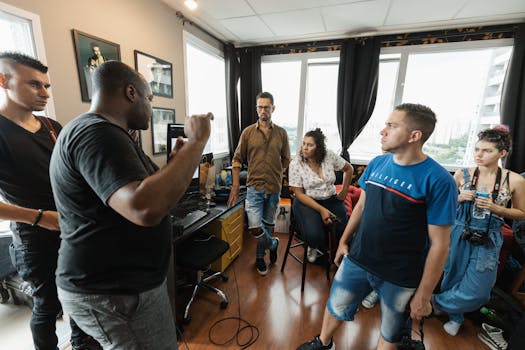 A diverse group of adults in an office having a creative discussion with large windows.