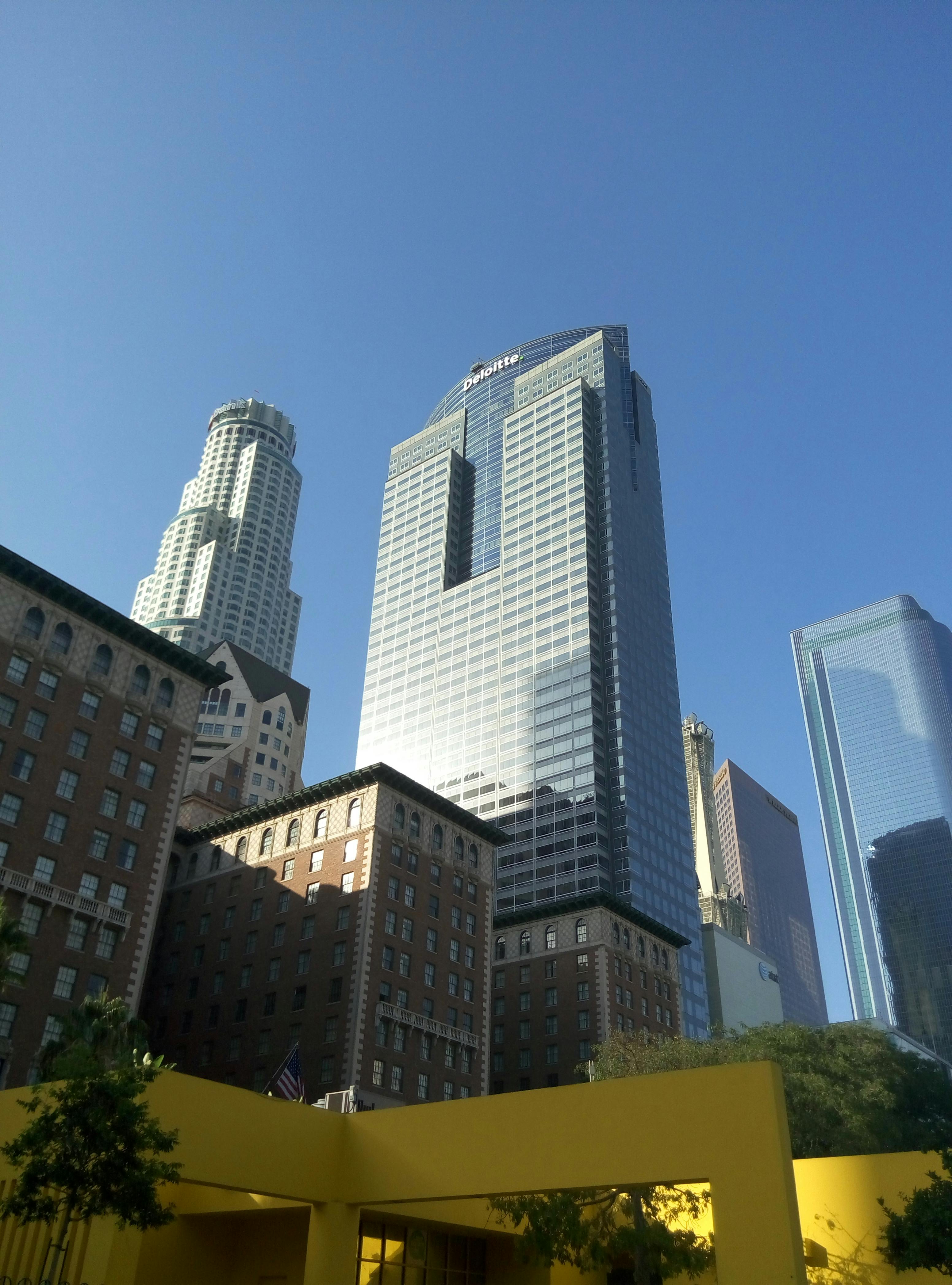 low angle shot of high rise buildings in the city under the blue sky